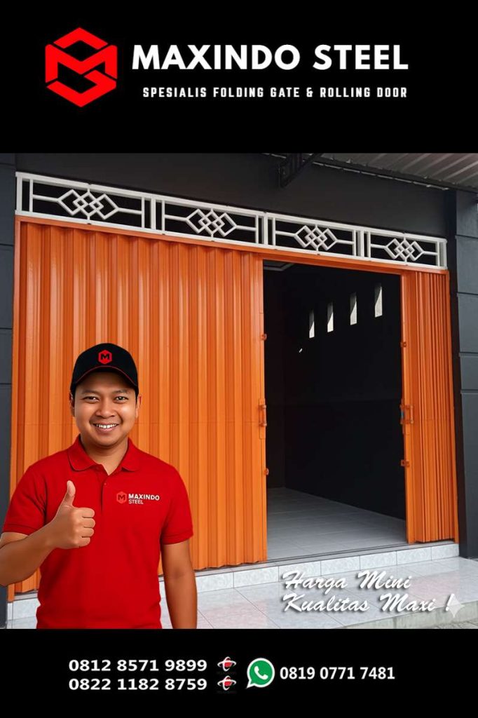 Teknisi Maxindo Steel sedang berpose di depan folding gate warna oranye pada bangunan ruko, sebagai promosi jasa pasang dan service folding gate di Pinang Ranti, Makasar, Jakarta Timur.